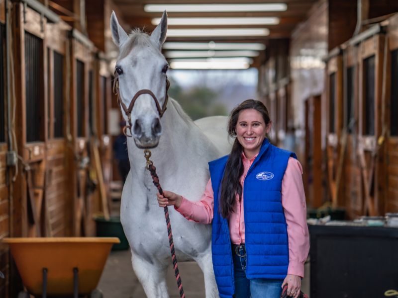 a vet staff standing next to a horse